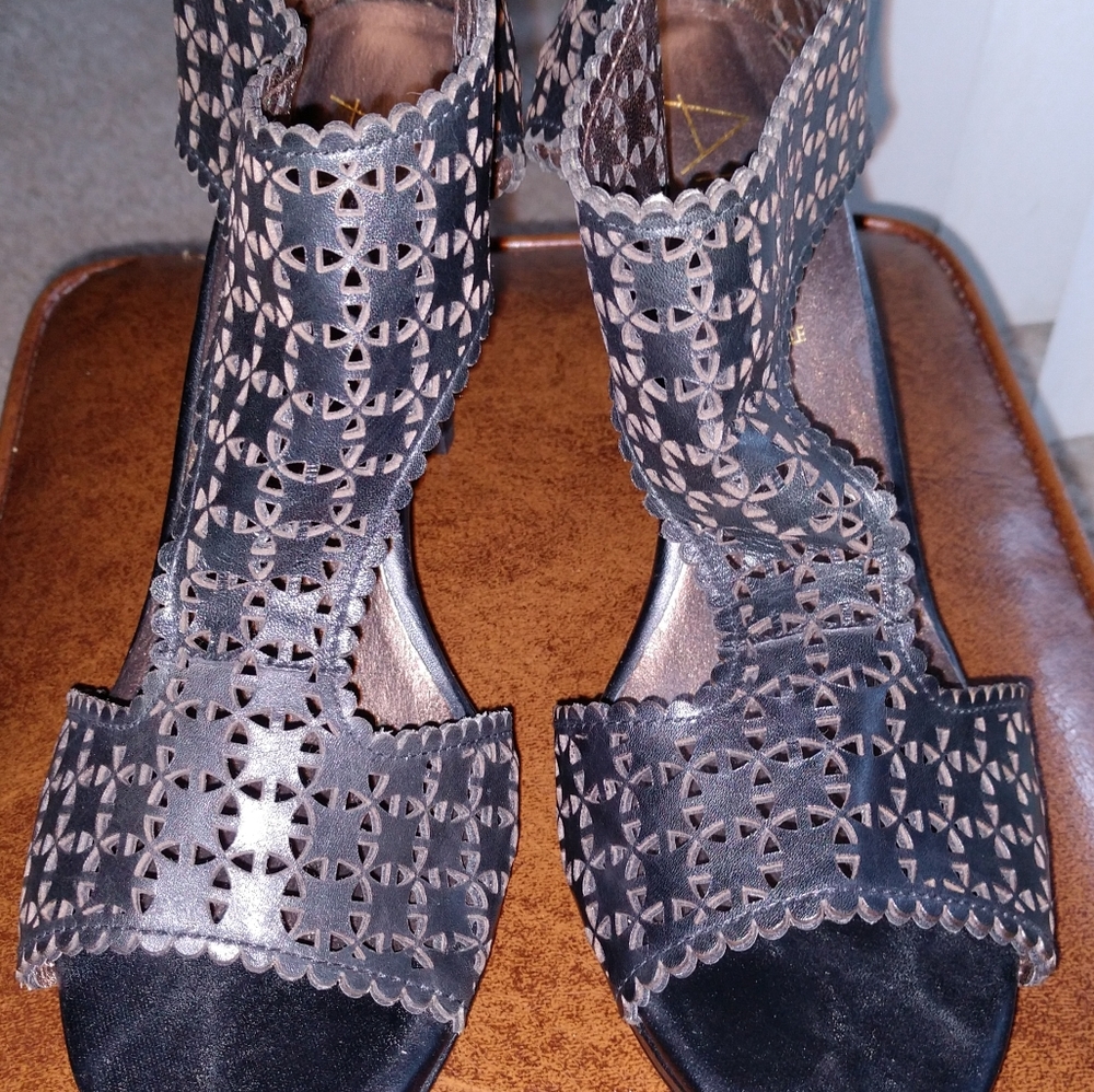Black laser cut open toe/side out heel. Never worn